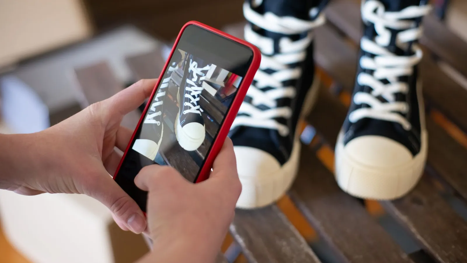 Mains cadrant la photo d'un produit au smartphone pour une publication de vente en ligne